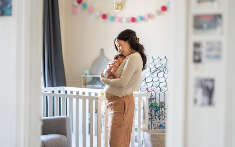 Woman holding her baby in the nursery